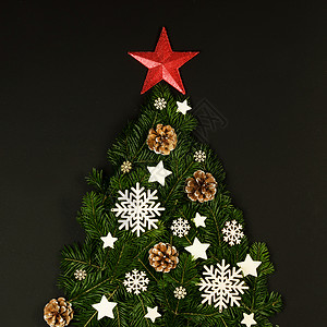 圣诞树由天然云杉树枝装饰而成,黑色背景上有红星,有的平放卡圣诞树卡图片