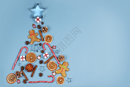 姜饼圣诞树圣诞树符号成姜饼干焦糖罐头塑造明星形式的礼物橙色鲍布,平躺与圣诞树的象征背景