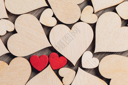 两颗木制的红心许多无色的木心中涂上两颗木制的红色心背景图片