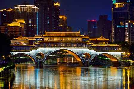 成都著名的地标安顺桥金河上,夜间照明与现代摩天大楼的背景,成都,四川,中国安顺桥夜间,中国传统的高清图片素材