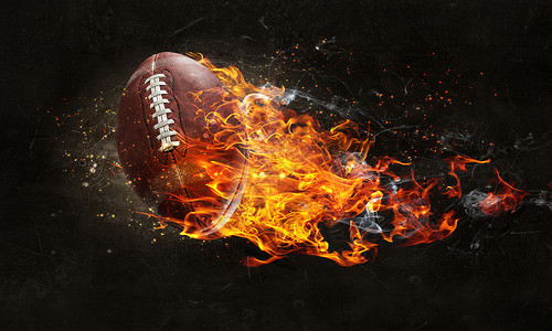 足球和火焰橄榄球黑暗背景下的火焰中美国足球比赛的背景