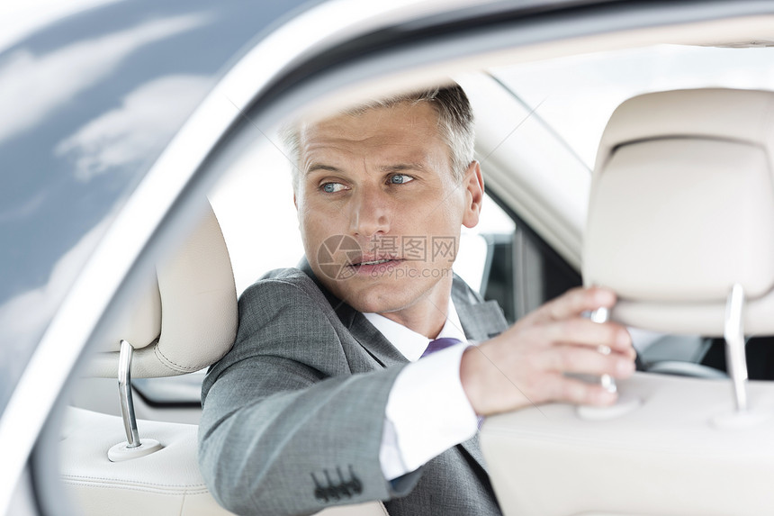 坐车里时,成熟的商人侧过头看图片
