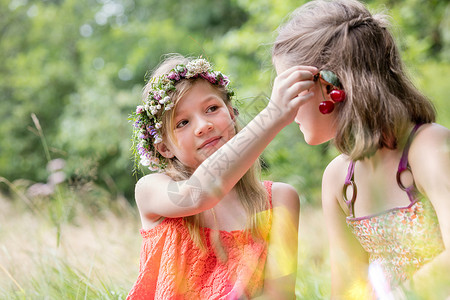 可爱的女孩抱着樱桃水果朋友的耳朵公园图片
