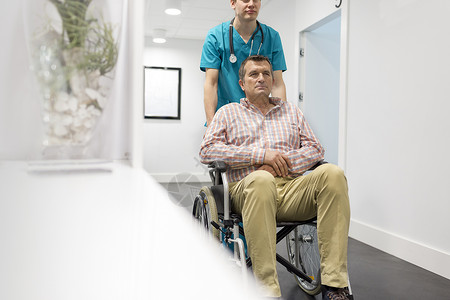 年轻护士医院把成熟的病人推轮椅上图片
