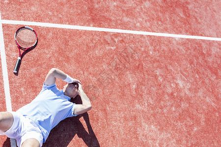 高角度的,失望的成熟男子,头手,而躺网球拍球场上夏季背景图片