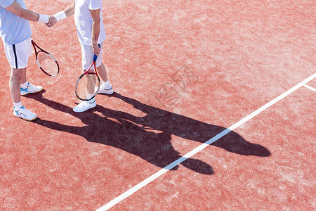 比赛期间,网球场上站着的成年男子握手的低段高清图片