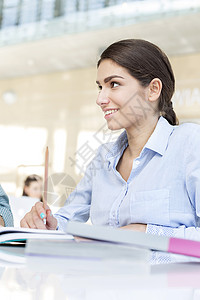 微笑的少女大学图书馆的桌子上看书图片