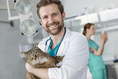带着猫的微笑医生的肖像背景图片