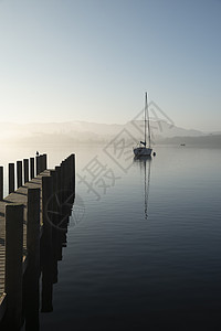 无峰不起浪美丽的拔掉插头的景观形象,帆船坐平静的湖水中,宁静的雾蒙蒙的秋日日出背景