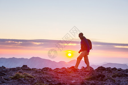 日落时美丽的夏季山脉中的徒步旅行场景背景图片