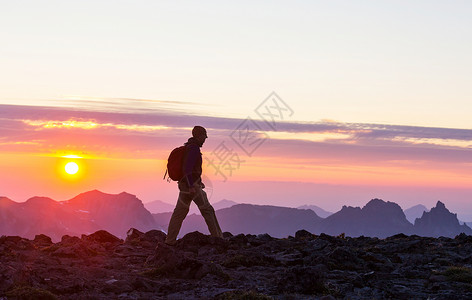 日落时美丽的夏季山脉中的徒步旅行场景背景图片