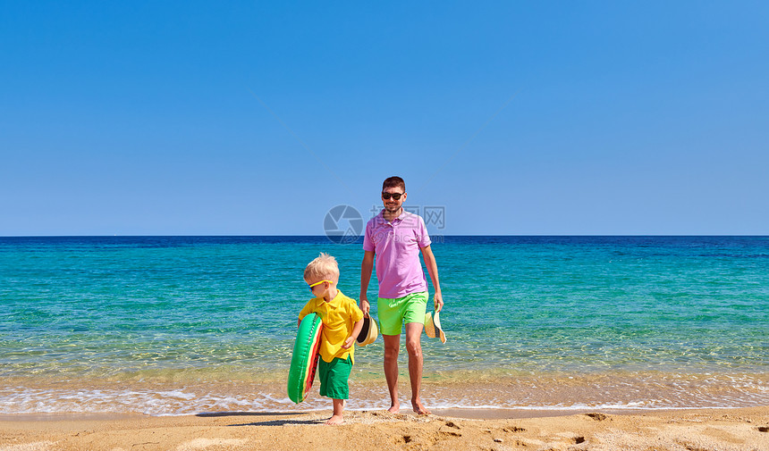 两岁的蹒跚学步的男孩父亲海滩上散步,着充气戒指暑假家庭假期希腊西索尼亚