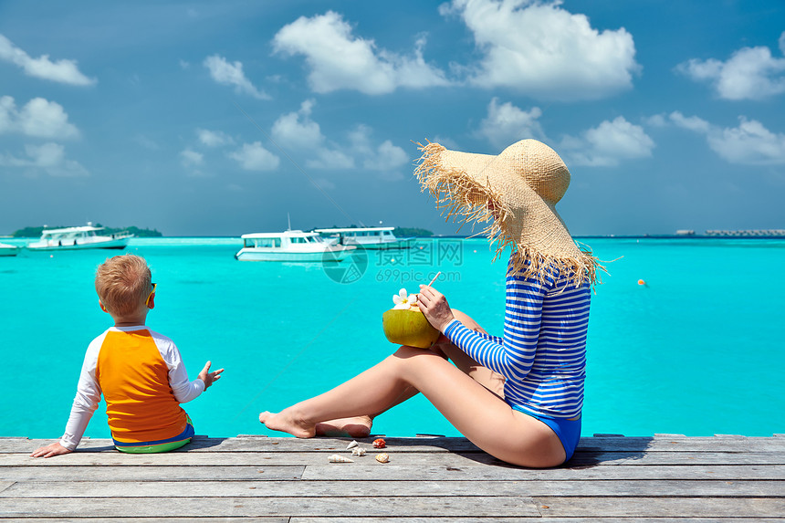三岁的蹒跚学步的男孩,母亲坐木制码头上马尔代夫的暑假家庭假期图片
