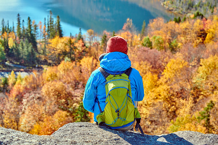 背包客男子徒步旅行艺术家的虚张声势秋天回声湖的景色法国公园的秋天颜色美国新罕布什尔州白山森林背景