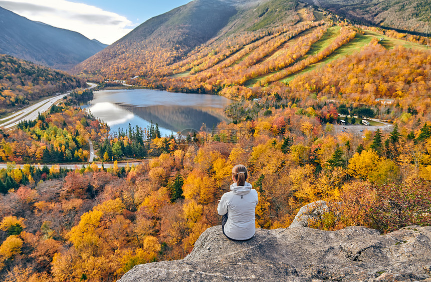 女子徒步旅行艺术家的虚张声势秋天回声湖的景色法国公园的秋天颜色美国新罕布什尔州白山森林图片