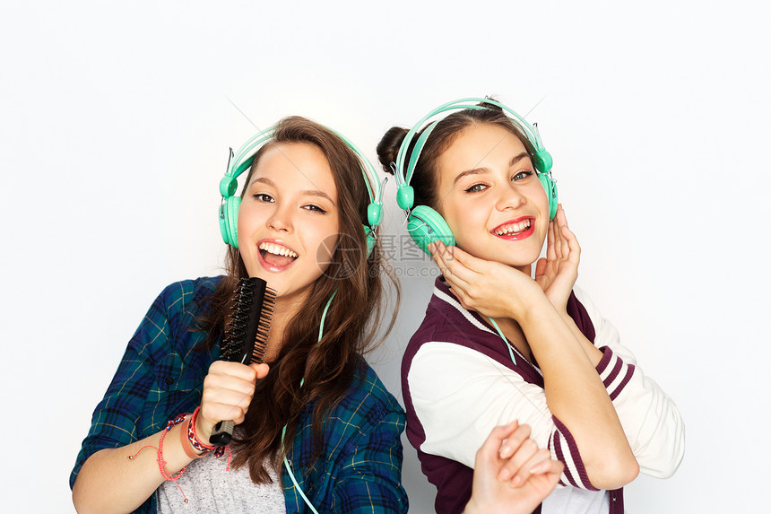 人,休闲技术的微笑的十几岁的女孩耳机听音乐唱歌梳子,并白色背景上玩十几岁的女孩戴着耳机听音乐图片