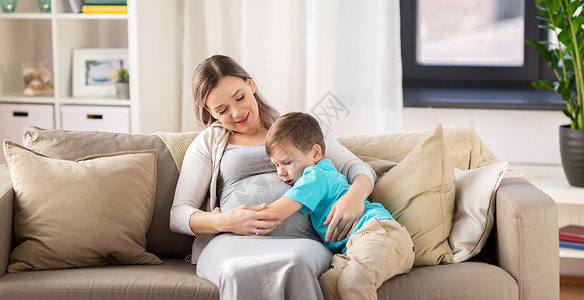 怀孕,人家庭观念快乐的怀孕母亲小儿子拥抱家里快乐怀孕的母子拥抱家里坐高清图片素材