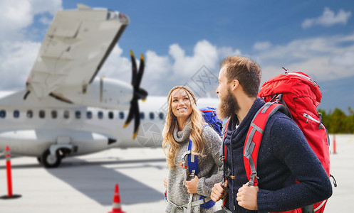 旅行游客飞机旅行,旅游人的几个游客带背包飞机上的机场背景几个带背包的游客飞机上背景