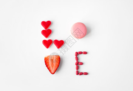 情人节,糖果糖果的文字爱由红色心形糖果,粉红色通心粉饼干草莓用糖果的爱图片