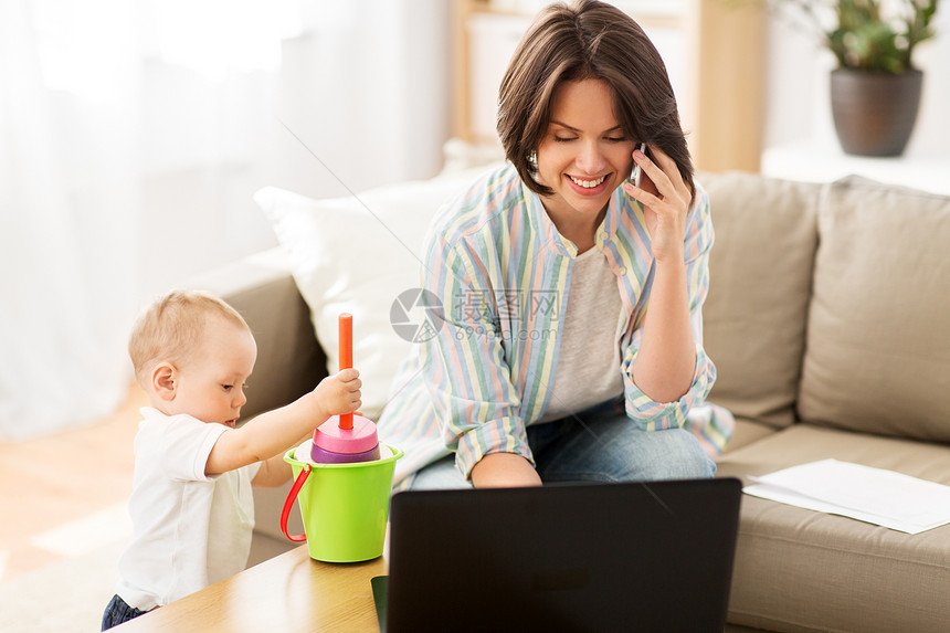 多任务,自由职业母亲的工作的母亲与婴儿儿子打电话家里的智能手机工作母亲婴儿智能手机上打电话图片