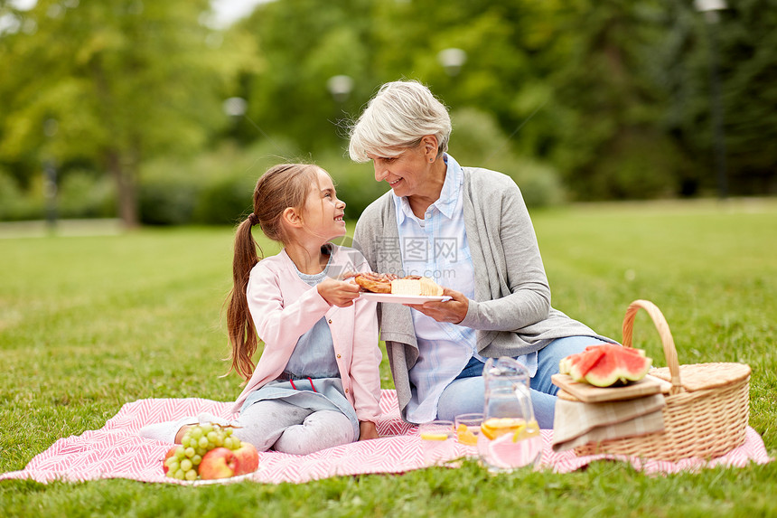 家庭休闲人的快乐的祖母孙女夏季公园野餐祖母孙女公园野餐图片