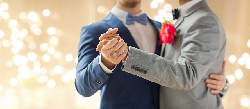 同婚姻的亲密的快乐男夫妇牵手跳舞婚礼上的节日灯光背景亲密的快乐男夫妇跳舞图片
