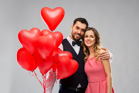 情人节,爱人的幸福的夫妇与红色心形气球灰色背景幸福的红色心形气球图片