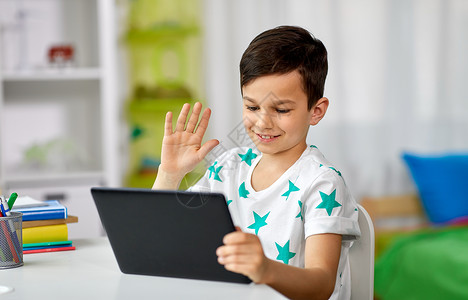 技术,沟通人的快乐的男孩与平板电脑视频聊天家平板电脑的男孩家视频聊天通信高清图片素材