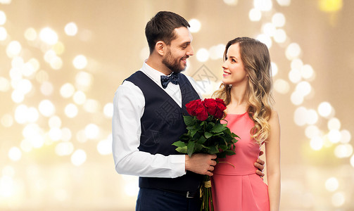 情人节,关系人的幸福的夫妇与鲜花拥抱节日的灯光背景情人节几花图片