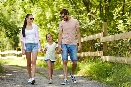 家庭休闲人的快乐的母亲父亲小女儿夏季公园散步快乐的家人夏天的公园散步图片