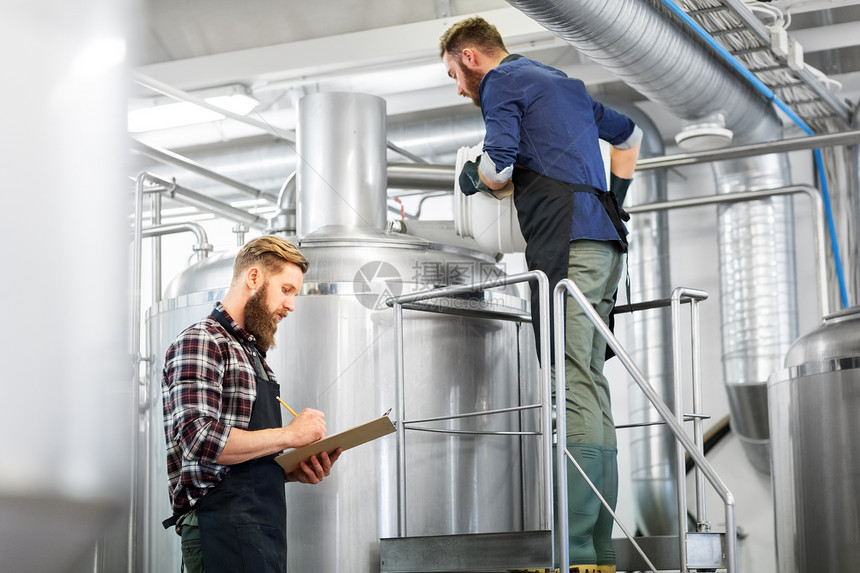 制造,商业人的男人与剪贴板麦芽工作啤酒厂啤酒厂水壶啤酒厂水壶啤酒厂剪贴板的男人图片