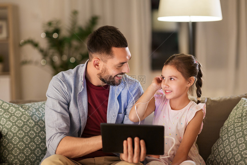 家庭,父亲技术快乐的父亲小女儿与平板电脑耳机家里听音乐父亲女儿平板电脑上听音乐图片