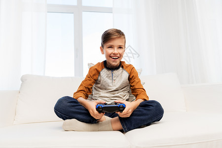 游戏,技术人的微笑男孩与游戏垫家里玩电子游戏快乐的男孩家里玩电子游戏图片