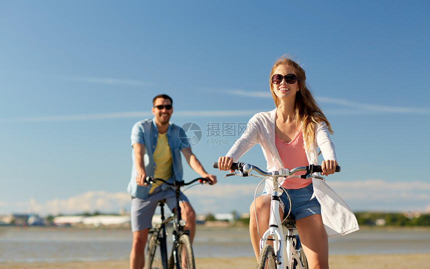 人们,休闲生活方式的快乐的轻夫妇骑自行车海滩上快乐的轻夫妇海边骑自行车图片