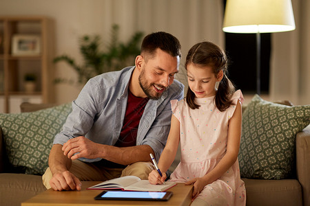 教育家庭观念快乐的父亲女儿,晚上家用书平板电脑作业父亲女儿作业图片