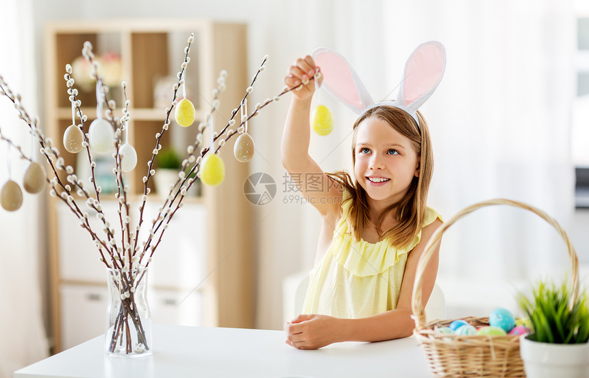 复活节,假日人们的快乐的女孩戴着兔子耳朵,头巾,家里用玩具鸡蛋装饰柳树枝女孩家用复活节彩蛋装饰柳树图片