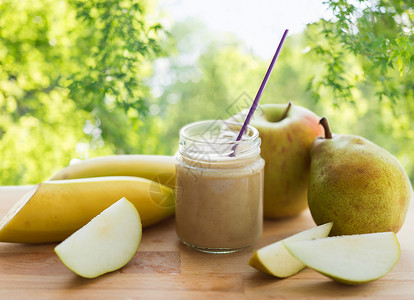 婴儿食品,健康饮食营养璃罐与苹果,梨香蕉果泥木制桌子上绿色自然背景带水果酱婴儿食品的罐子背景图片