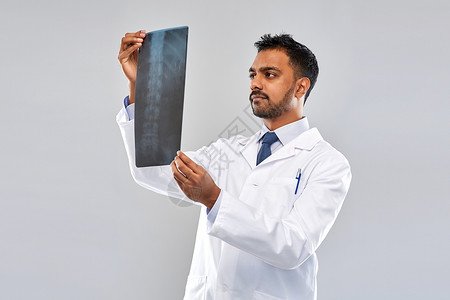 医学,医疗人的印度医生灰色背景下看脊柱X线印度医生看脊柱X光图片