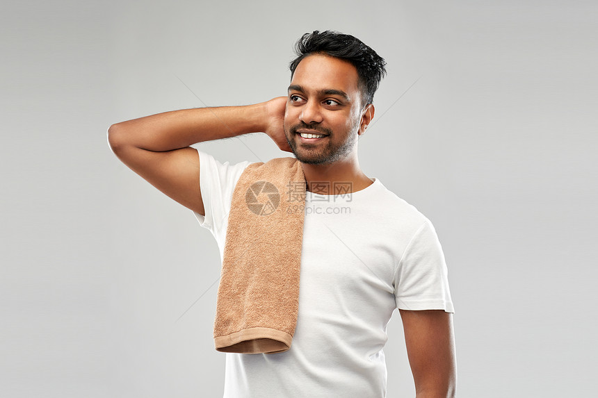 修饰人的微笑的印度男子与浴巾灰色的背景微笑的印度男人带着毛巾灰色的背景上图片