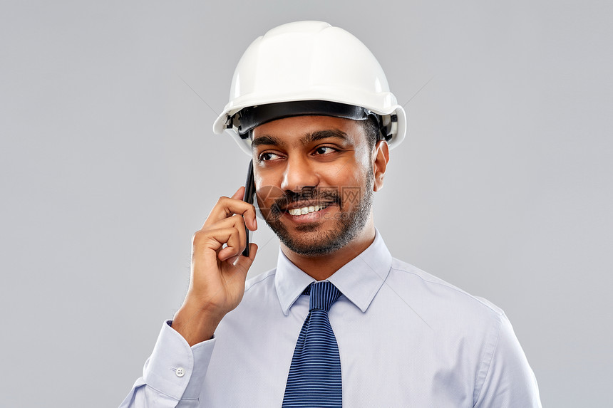 建筑,建筑业务建筑微笑的印度建筑师商人头盔呼叫智能手机灰色背景印度建筑师头盔呼叫智能手机图片