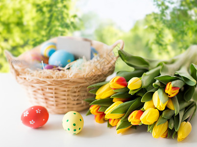 咖色象复活节,假日,传统象彩色鸡蛋篮子郁金香花桌子上绿色的自然背景彩色复活节彩蛋郁金香花背景