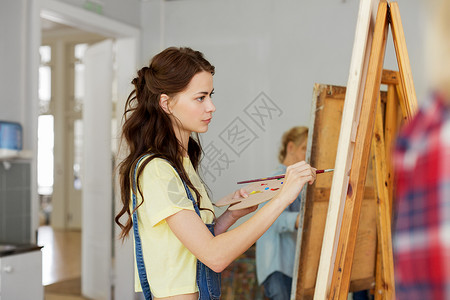 艺术学校,创造力人的妇女与画架,调色板画笔工作室艺术学校工作室画画画架的女人油漆高清图片素材