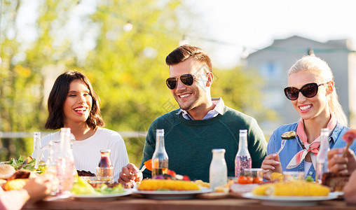 休闲人们的快乐的朋友夏天的屋顶聚会上吃喝快乐的朋友屋顶聚会上吃喝图片