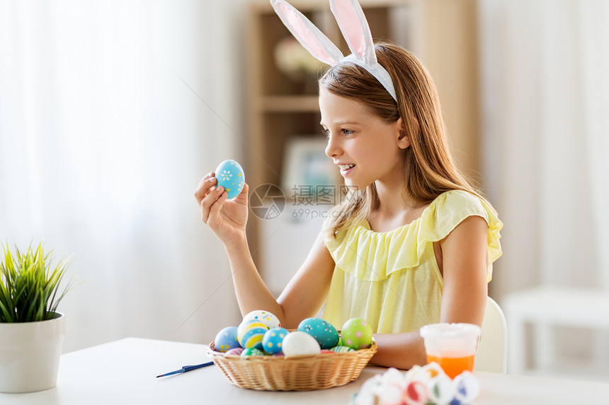 复活节,假期人们的快乐的女孩戴着兔子耳朵,头带着彩色鸡蛋家里家里彩色复活节彩蛋的快乐女孩图片