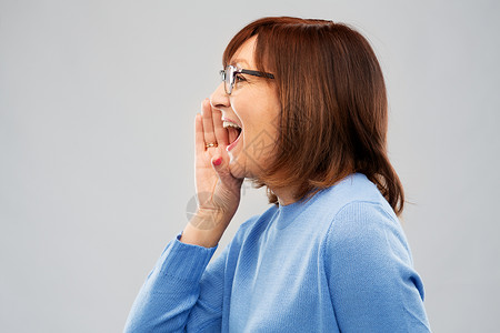 戴眼镜的老年女子在呼喊图片