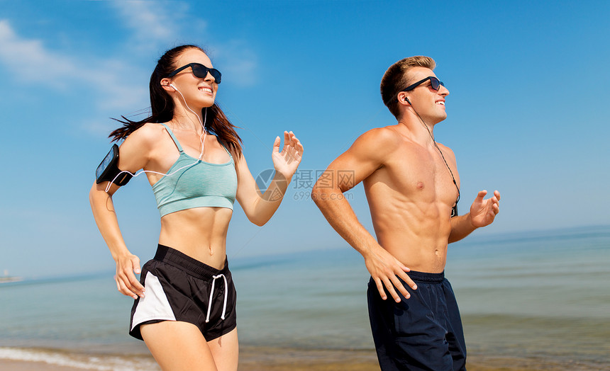 健身,运动技术快乐的夫妇与耳机手臂乐队运行夏季海滩夫妇带着电话手臂乐队海滩上跑步图片