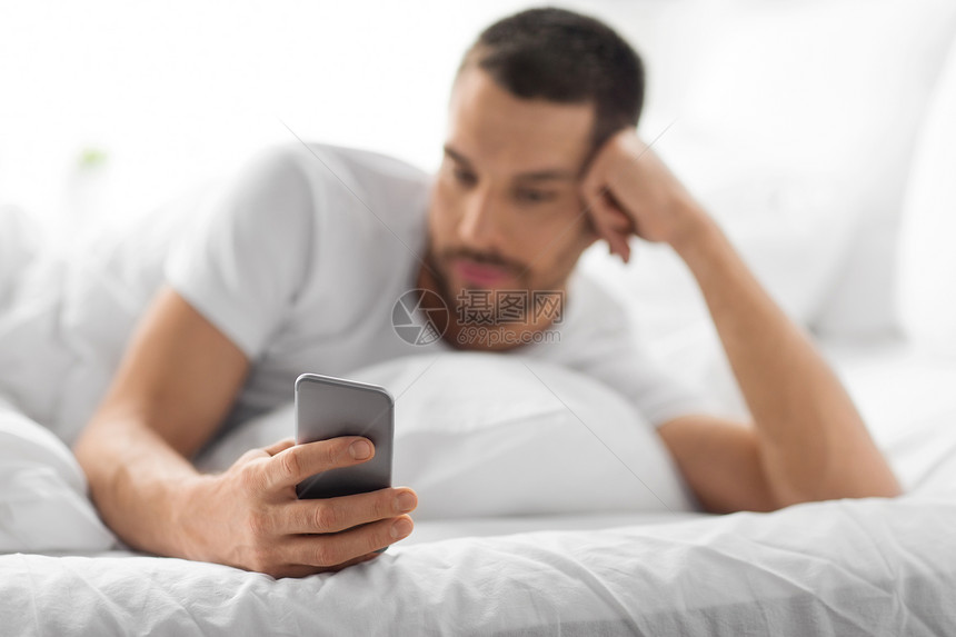 技术,沟通人的轻人智能手机上发短信家里早上把带智能手机的男人关床上图片