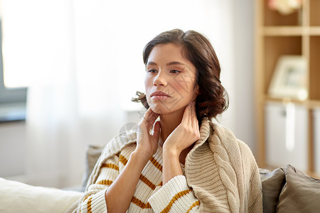 淋巴疏通寒冷健康问题的生病的女人触摸她的淋巴结家里生病的女人家里摸她的淋巴结背景