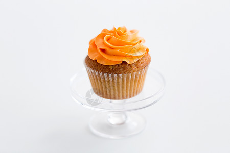 食品,糕点糖果纸杯蛋糕与橙色奶油霜璃糖果站白色背景蛋糕上糖霜图片