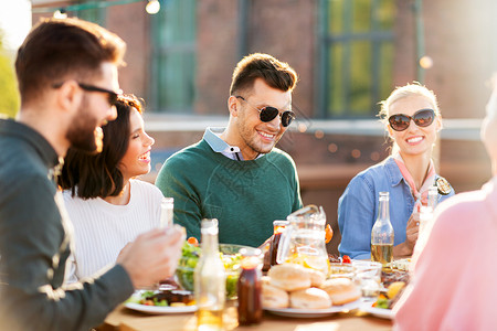 休闲人们的快乐的朋友夏天的屋顶聚会上吃喝快乐的朋友屋顶聚会上吃喝背景图片